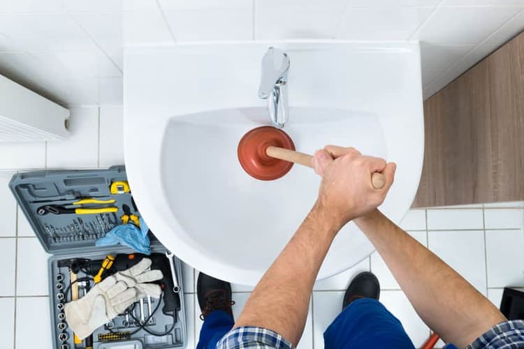 clearing a clogged drain with a plunger