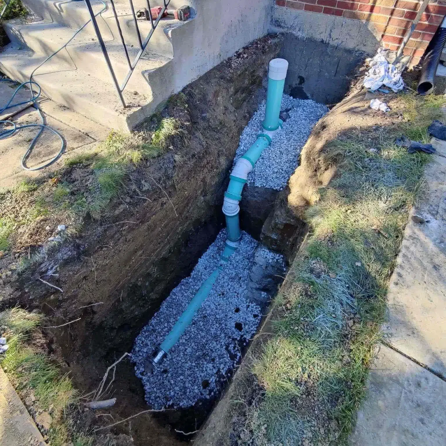 Reid & Pederson installing new sewer line in Crete with gravel bedding during underground pipe repair