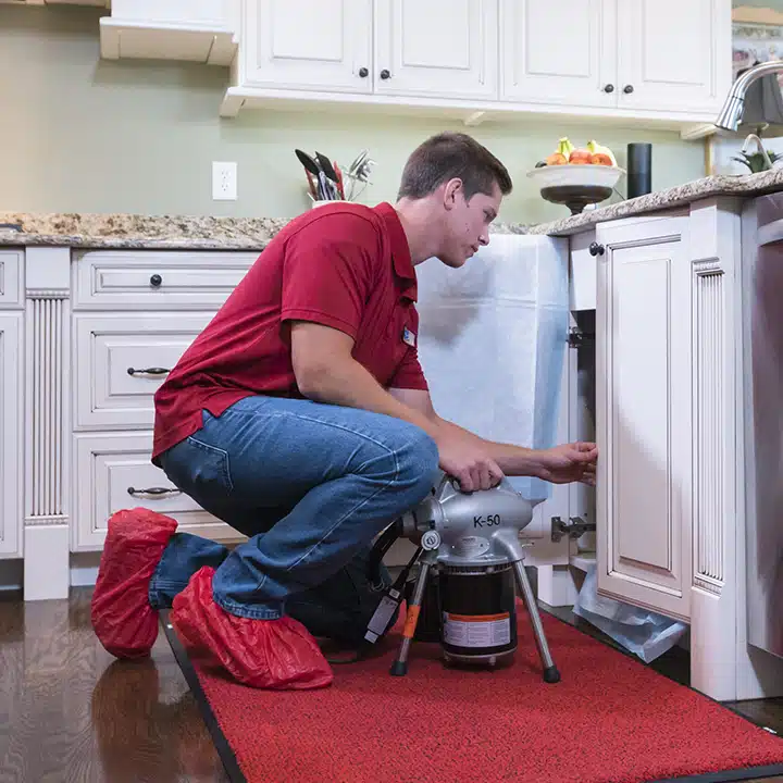 Reid and Pederson technician using a Rigid K-50 section drain machine in residential kitchen drain in Crete, IL.