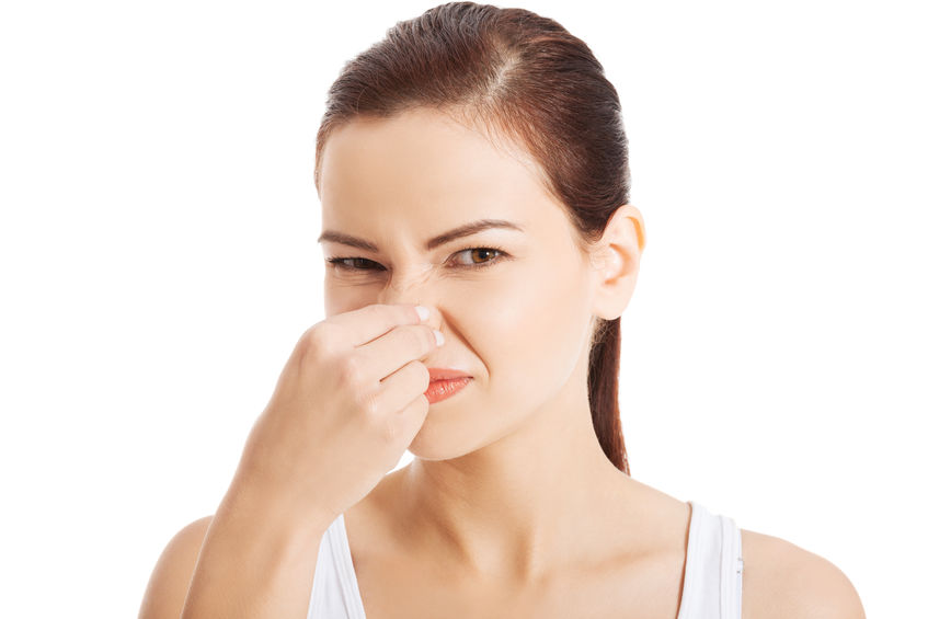 woman pinching nose because house smells like sewage