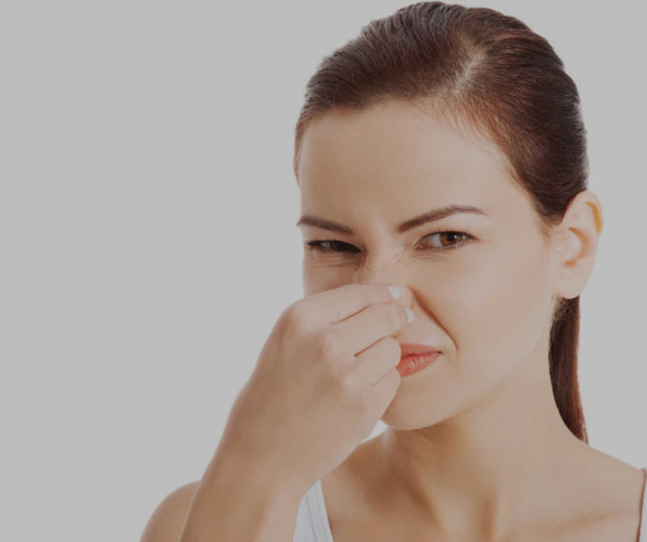 woman pinching nose closed due to sewer smell in house