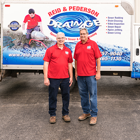 Reid & Pederson owners in front of truck