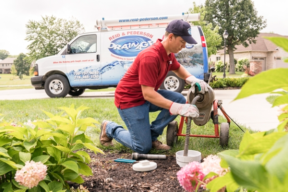 professional sewer technician rodding sewer line